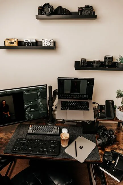 Gros plan sur un ordinateur portable affichant la page de connexion Twitter, accompagné d’un smartphone et d’une plante en pot dans un espace de travail lumineux.